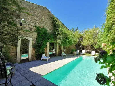 a swimming pool in front of a building at Gîte Brassens in Pouzols-Minervois