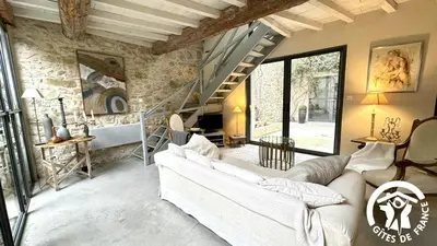 a living room with a couch and a staircase at Gîte Brassens in Pouzols-Minervois