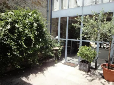 a building with plants and a bench in front of it at Gîte Brassens in Pouzols-Minervois