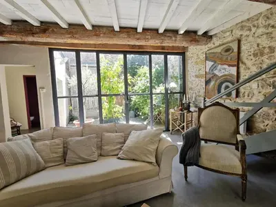 a living room with a couch and a large window at Gîte Brassens in Pouzols-Minervois