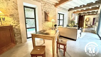 a living room with a table and a piano at Gîte Brassens in Pouzols-Minervois