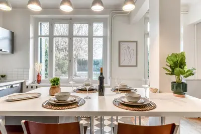 a kitchen with a table with plates and wine glasses at Big House - Parking Privée - Piscine - Wifi - tout équipée in Carcassonne
