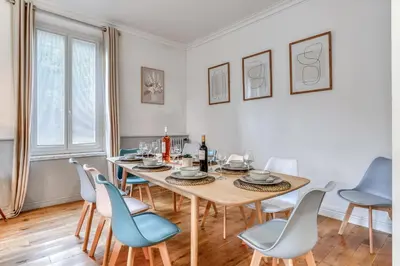 a dining room with a wooden table and chairs at Big House - Parking Privée - Piscine - Wifi - tout équipée in Carcassonne