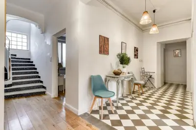 a hallway with a checkered floor and a blue chair at Big House - Parking Privée - Piscine - Wifi - tout équipée in Carcassonne