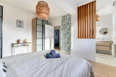 a bedroom with a large bed with a blue towel on it at Big House - Parking Privée - Piscine - Wifi - tout équipée in Carcassonne