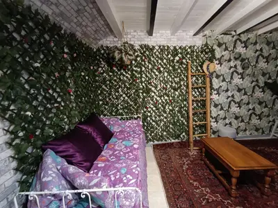 a living room with a couch and a wall with flowers at les Lavandes in Saint-Paul-de-Fenouillet