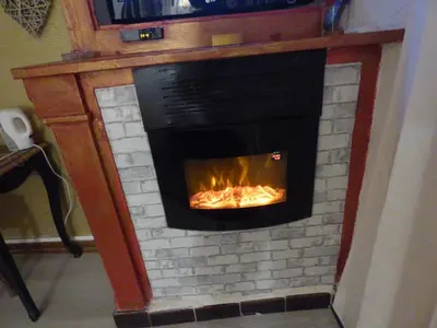 a brick fireplace with a fire in it at les Lavandes in Saint-Paul-de-Fenouillet