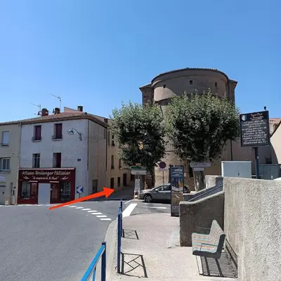 an empty street with an old building and a car at les Lavandes in Saint-Paul-de-Fenouillet