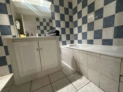 a bathroom with a tub and a sink and a mirror at Studio de 30 m2 centre-ville NARBONNE in Narbonne