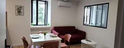 a living room with a red chair and a table at Le maillot VII in Castres