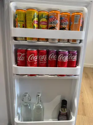 an open refrigerator filled with drinks and soda at La perle limouxine -Studio in Limoux