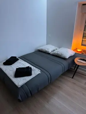 a bed with a black bag sitting on top of it at La perle limouxine -Studio in Limoux