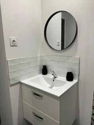 a white bathroom with a sink and a mirror at La perle limouxine -Studio in Limoux