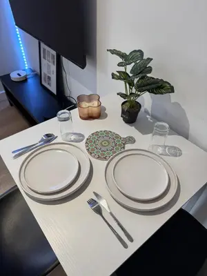 a table with three white plates and silverware on it at La perle limouxine -Studio in Limoux
