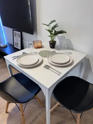 a white table with two chairs and plates on it at La perle limouxine -Studio in Limoux