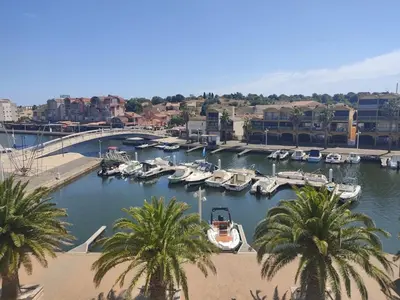 a group of boats in a marina with palm trees at Studio 3 pers à Gruissan - Vue Port - Parking - Climatisation Mobile - FR-1-796-89 in Gruissan
