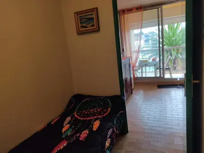 a bedroom with a bed and a door to a balcony at Studio 3 pers à Gruissan - Vue Port - Parking - Climatisation Mobile - FR-1-796-89 in Gruissan