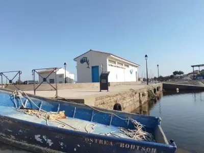 a blue boat sitting in the water near a dock at Studio 3 pers à Gruissan - Vue Port - Parking - Climatisation Mobile - FR-1-796-89 in Gruissan
