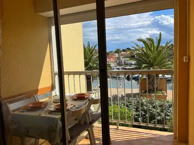 a table on a balcony with a view of the ocean at Studio 3 pers à Gruissan - Vue Port - Parking - Climatisation Mobile - FR-1-796-89 in Gruissan