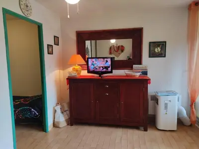 a room with a television on a dresser with a mirror at Studio 3 pers à Gruissan - Vue Port - Parking - Climatisation Mobile - FR-1-796-89 in Gruissan