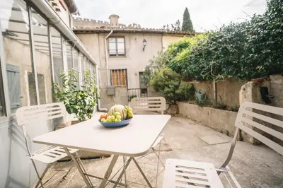 a table and chairs with a bowl of fruit on it at Face à la cité, Terrasse Et Climatisation - AE in Carcassonne