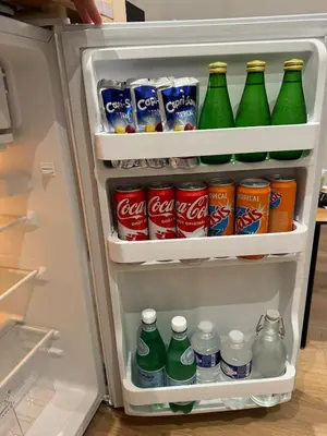 an open refrigerator filled with drinks and soda at La perle du centre - Studio in Limoux