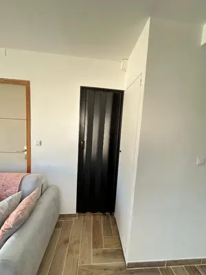 a room with a black door and a couch at Rubis in Lapalme