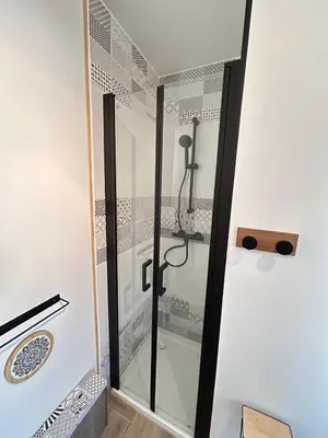 a shower with a glass door in a bathroom at Rubis in Lapalme