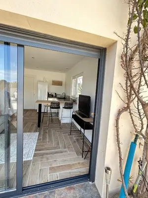 a sliding glass door leading into a kitchen and dining room at Rubis in Lapalme