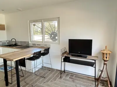 a kitchen with a desk with a television and a table at Rubis in Lapalme