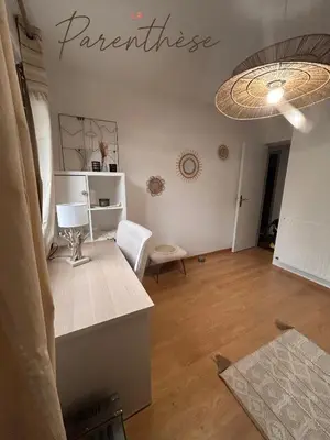 a living room with a table and a lamp on the wall at La parenthèse in Pamiers