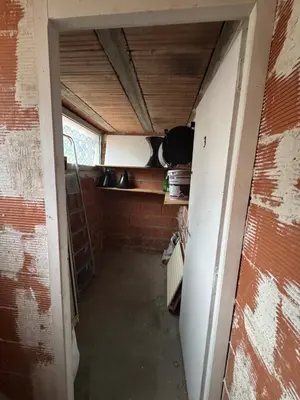 an empty room with a kitchen with a brick wall at La parenthèse in Pamiers