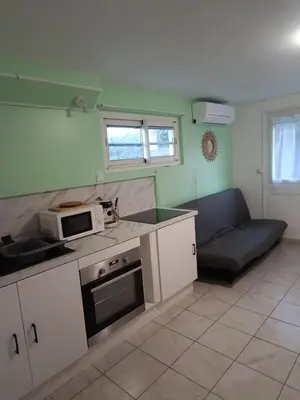 a kitchen with a microwave and a couch in a room at Appartement Salles d 'Aude in Salles-d'Aude