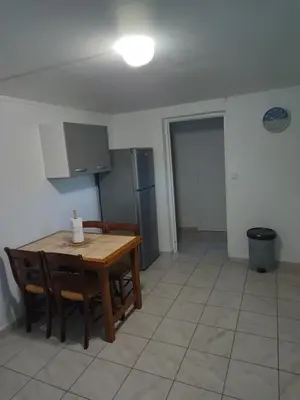 a kitchen with a table and chairs and a refrigerator at Appartement Salles d 'Aude in Salles-d'Aude