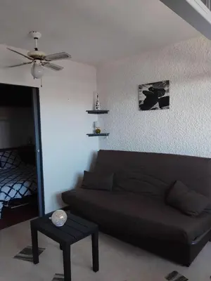 a living room with a couch and a ceiling fan at STUDIO Bis - PLAGE in Port-la-Nouvelle