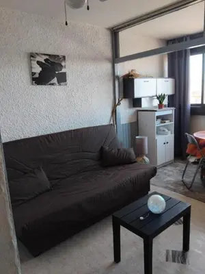 a living room with a couch and a table at STUDIO Bis - PLAGE in Port-la-Nouvelle