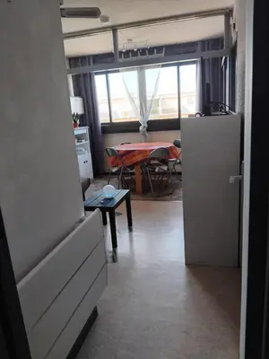 a kitchen and dining room with a table and a refrigerator at STUDIO Bis - PLAGE in Port-la-Nouvelle