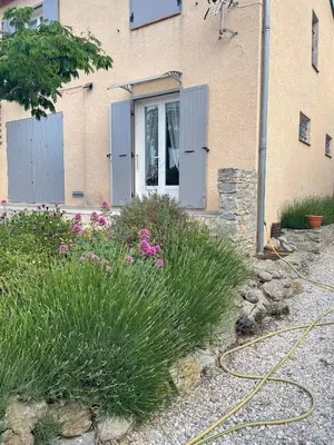 a house with a garden with flowers and a hose at Entre Mer et Vigne Caves in Caves