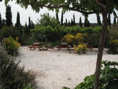 two picnic tables and benches in a garden at L'esprit Garrigue Caves in Caves