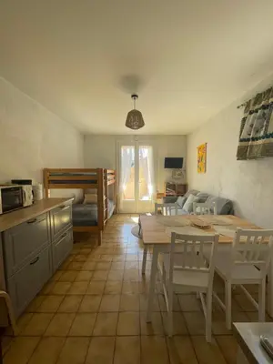 a kitchen and living room with a table and chairs at L'esprit Garrigue Caves in Caves
