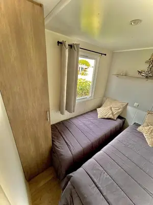 a small bedroom with two beds and a window at Tiny house Port la Nouvelle in Port-la-Nouvelle