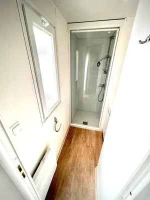 a bathroom with a walk in shower next to a window at Tiny house Port la Nouvelle in Port-la-Nouvelle