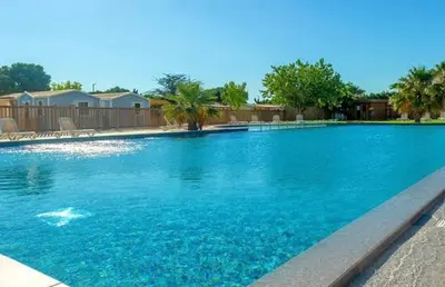 a large swimming pool with blue water at Tiny house Port la Nouvelle in Port-la-Nouvelle