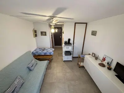 a living room with a couch and a ceiling fan at Appartement Studio-Cabine PORT-LA NOUVELLE PN290-074 in Port-la-Nouvelle