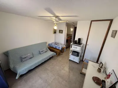a living room with a bed and a ceiling fan at Appartement Studio-Cabine PORT-LA NOUVELLE PN290-074 in Port-la-Nouvelle