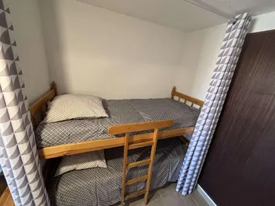a small bedroom with a bed and a wooden table at Appartement Studio-Cabine PORT-LA NOUVELLE PN290-074 in Port-la-Nouvelle