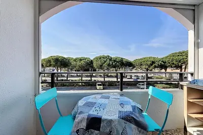 a room with a table and chairs and a window at Le Cordier - Apartment near the harbor in Gruissan