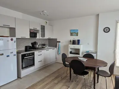 a kitchen with a wooden table and a table and chairs at Escapade à Nailloux in Nailloux