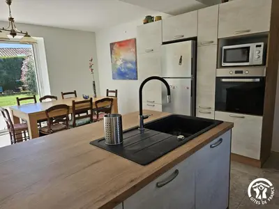 a kitchen with a sink and a kitchen with a table at La surprise des jumelles in Castres