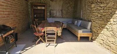 a table and chairs in a room with a couch at La surprise des jumelles in Castres